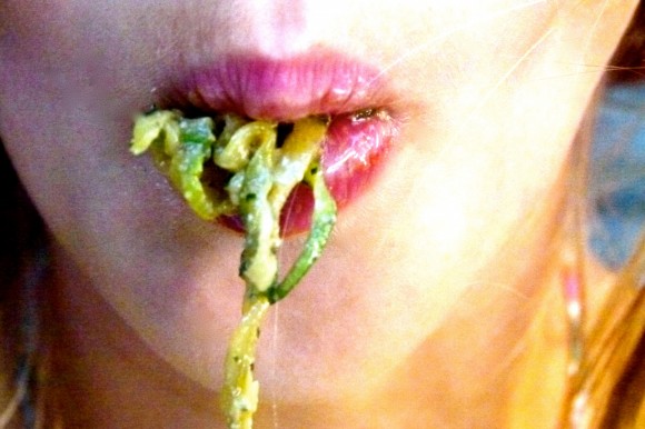 girl eating seafood “zucc-ghetti“  ( zucchini spaghetti ) with fresh herb and walnut pesto