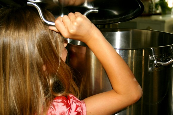 Child looking into kitchen pot