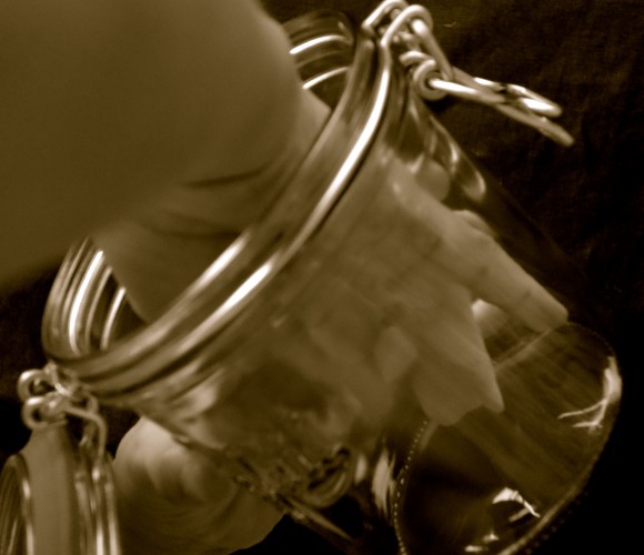 child's hand in glass jar