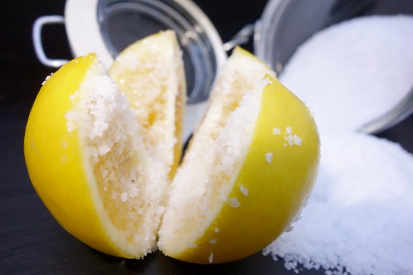 close up shot of Meyer lemon with salt and a glass jar ready to be preserved