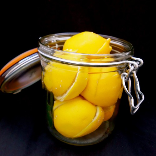 quartered and salted lemons in glass jar