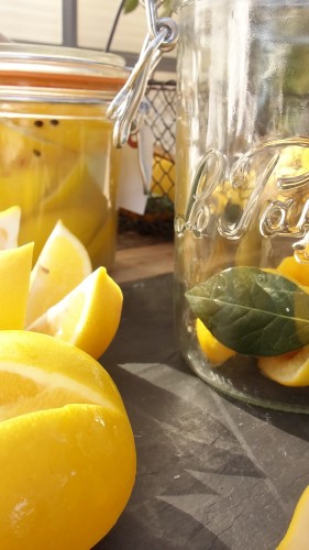 quartered and salted lemons  with lemon juice in glass jar