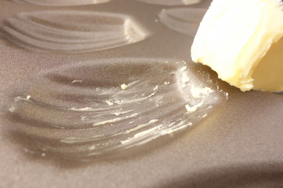 melted butter  in a Madeleine baking pan for vanilla bean Madeleines for valentines day