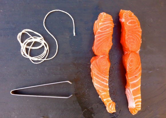 salmon filets with string and tongs